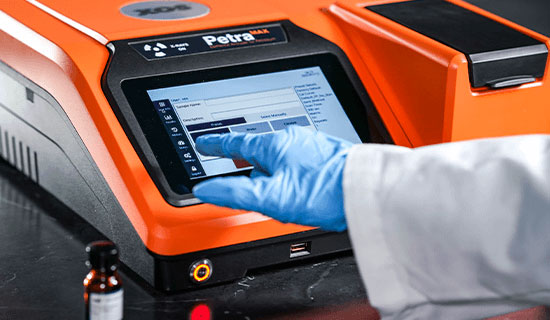 PetraMAX analyzer testing a liquid plastic sample in a laboratory